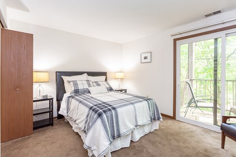 a bedroom with a bed and a door leading to a balcony